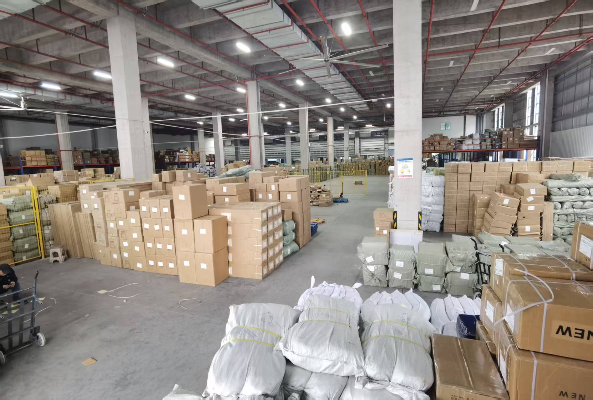 义乌大货仓库内成批堆放的纸箱、打包货物与托盘